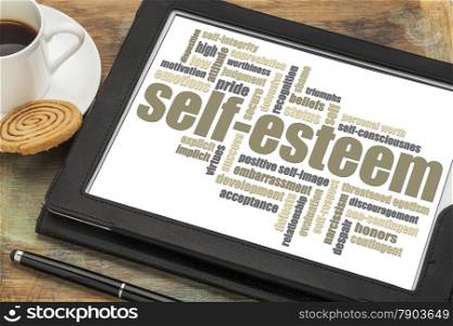 self-esteem word cloud on a digital tablet with cup of coffee