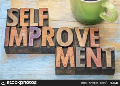 self improvement - word abstract in letterpress wood type printing blocks stained by color inks with a cup of coffee