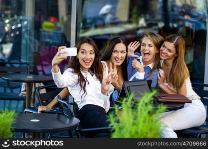 Selfie Four women sitting in a cafe on the street