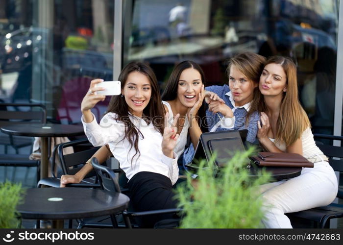 Selfie Four women sitting in a cafe on the street