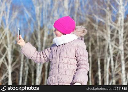 Selfie in park. Girl making selfie photo in winter park