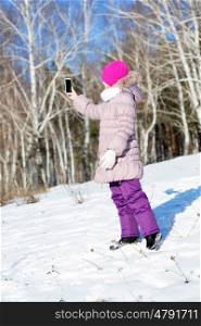 Selfie in park. Girl making selfie photo in winter park