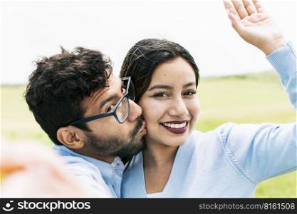 Selfie of a young couple kissing, Lifestyle of a cute couple taking a selfie, couple in love taking a selfie, concept of couples in love selfies