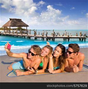 Selfie photo of young friends group in a tropical beach lying on sand