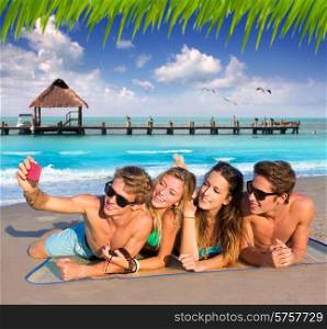 Selfie photo of young friends group in a tropical beach lying on sand