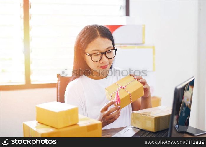 selling online ecommerce shipping online shopping delivery and order startup small business owner working / asian young woman packing cardboard box parcel delivery to customer cash on delivery