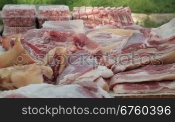 Selling pork meat at street market, vendor serving customer
