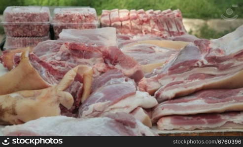 Selling pork meat at street market, vendor serving customer