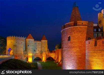 Semicircular fortified medieval outpost Barbican in the Old Town of Warsaw at night, Poland
