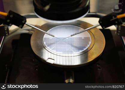 Semiconductor silicon wafer undergoing probe testing. Selective focus.