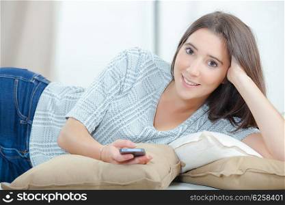 Sending a text message from her sofa