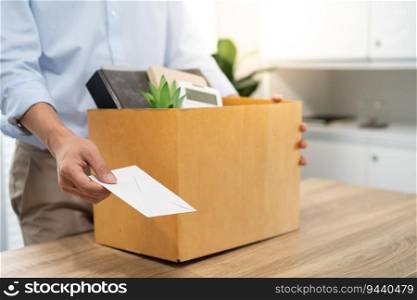 sending resignation letter to boss and Holding Stuff Resign Depress or carrying cardboard box by desk in office.