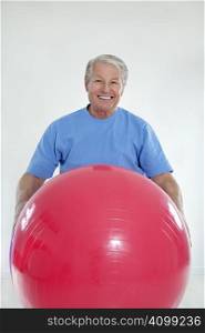 senior adult exercising with fitness ball in gym