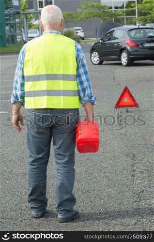 senior aged man holding gas can to refill his car