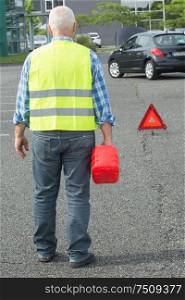 senior aged man holding gas can to refill his car