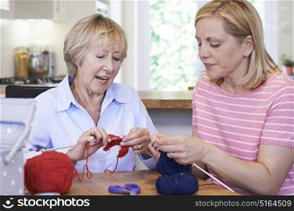 Senior And Mature Female Friends Knitting At Home Together