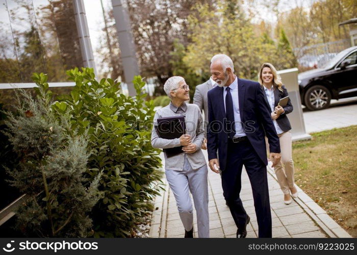 Senior and young businesspeople walking outdoor business office