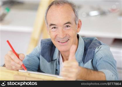 senior as master craftsman holding thumbs up