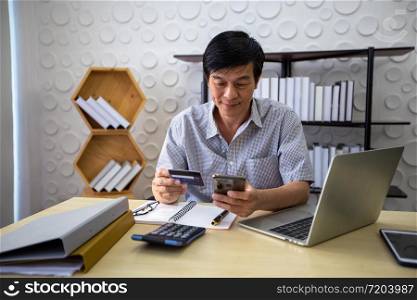 Senior Asian man using smart phone shopping online and paying with credit card
