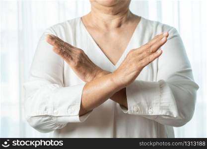 Senior asian woman say no holding two arms crossed