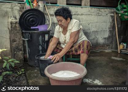 Senior asian woman washing cloths by hand