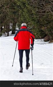 senior at the snow in winter nordic walking