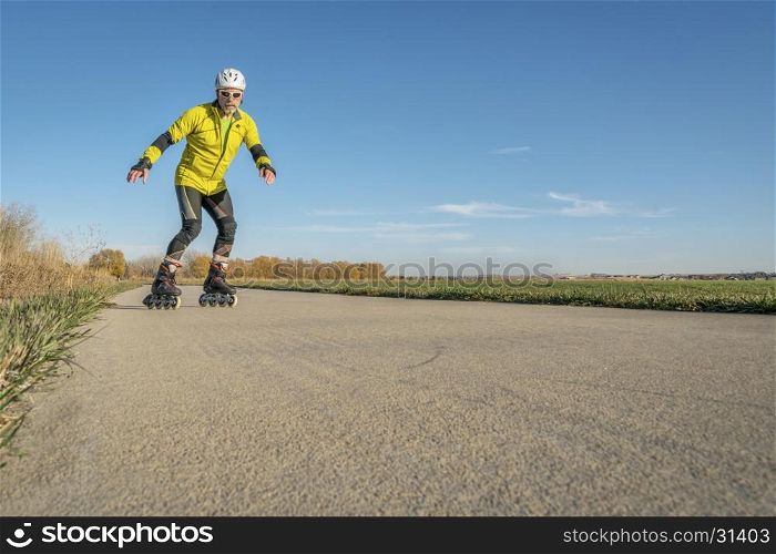 Senior athletic male is inline skating on the Poudre RIver Trail in Colorado, late fall scenery