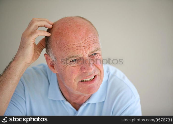 Senior bald man scratching his head