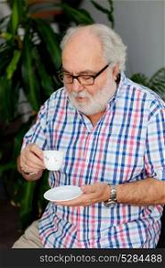 Senior bearded man drinking coffee at home