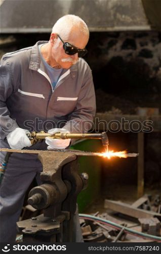 senior blacksmith working in workshop