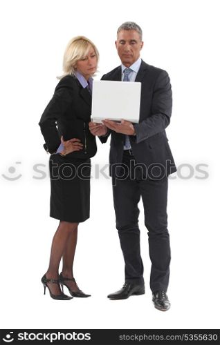 Senior business couple stood with laptop