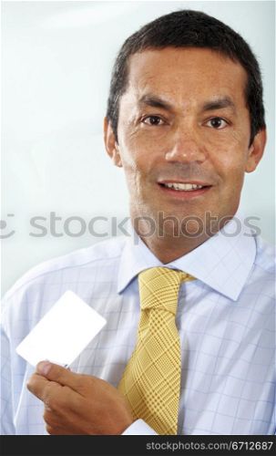 senior business man holding a business card in his office