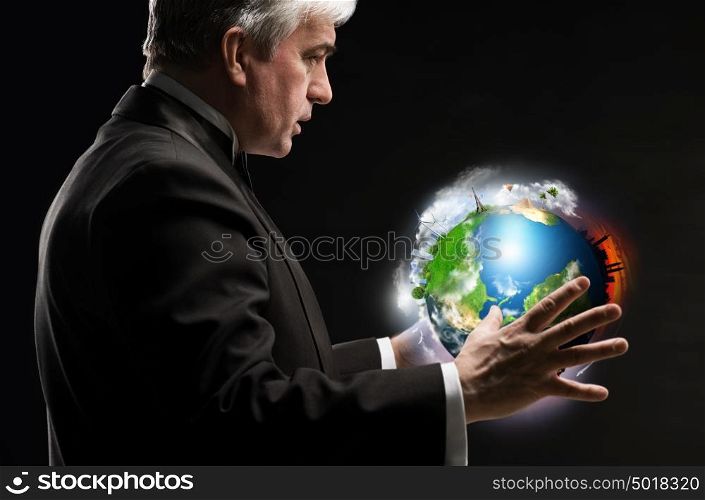Senior business man holding planet in his arms and controlling it