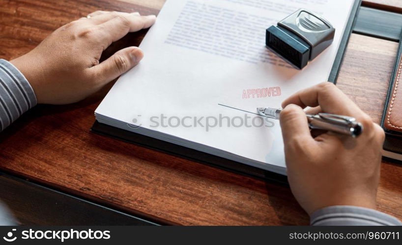 senior business man male hand putting or signing signature in the certificate contract after approve stamp on loan document agreement lawyer hand concept