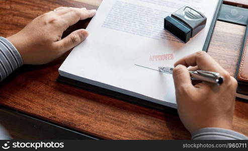 senior business man male hand putting or signing signature in the certificate contract after approve stamp on loan document agreement lawyer hand concept