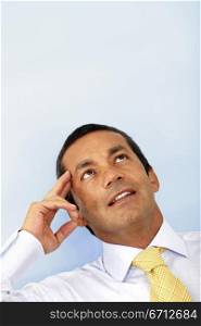 senior business man portrait with a pensive look over a light blue background