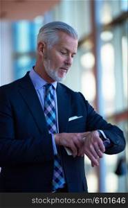 senior business man talk on mobile phone at modern bright office interior