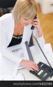 Senior business woman making phone calls at office