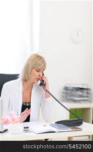 Senior business woman speaking phone at office
