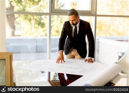 Senior businessman analyzes a project in the office on table