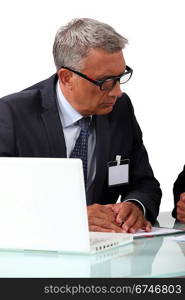 Senior businessman attentively listening to colleague