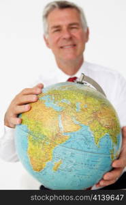 Senior businessman holding globe