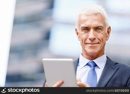 Senior businessman holding touchpad . Senior businessman holding touchpad outdoors