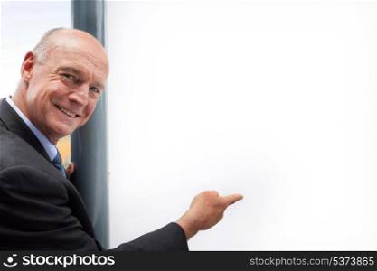 Senior businessman pointing at copyspace