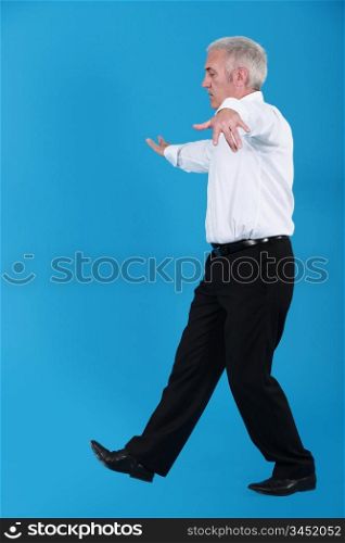 senior businessman pretending to walk on wire