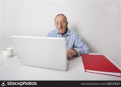 Senior businessman using laptop at office desk