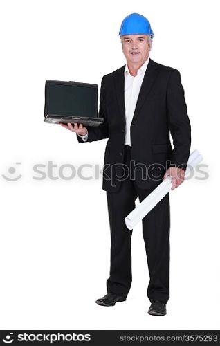 senior businessman wearing a helmet and holding a blueprint and a laptop