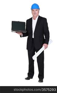 senior businessman wearing a helmet and holding a blueprint and a laptop