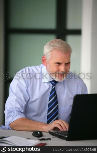 Senior businessman working-away at his desk