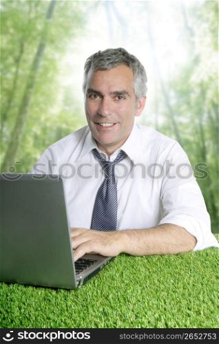 senior businessman working green grass desk computer forest jungle